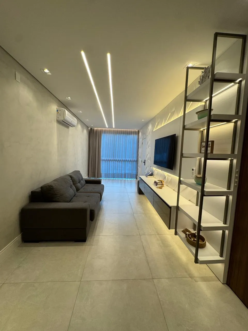 Sala de estar com estante, TV e quadro decorativo