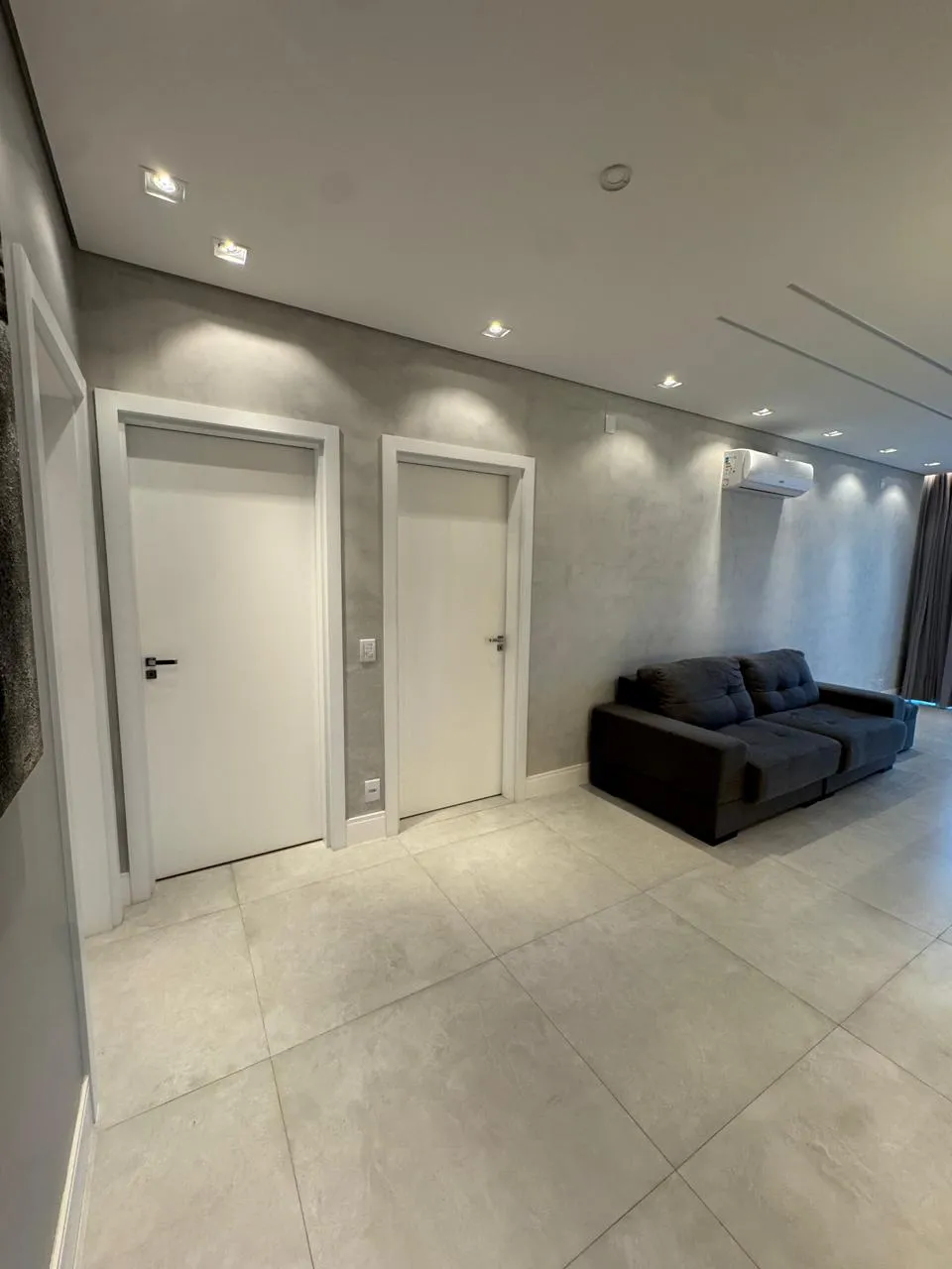 Corredor com sofá, TV e vista da janela ao fundo