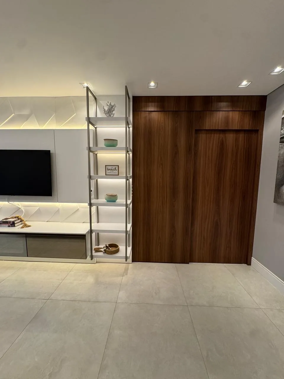 Sala de estar com estante e TV, outro ângulo
