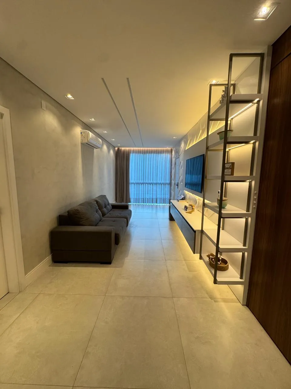 Sala de estar com sofá e corredor ao fundo
